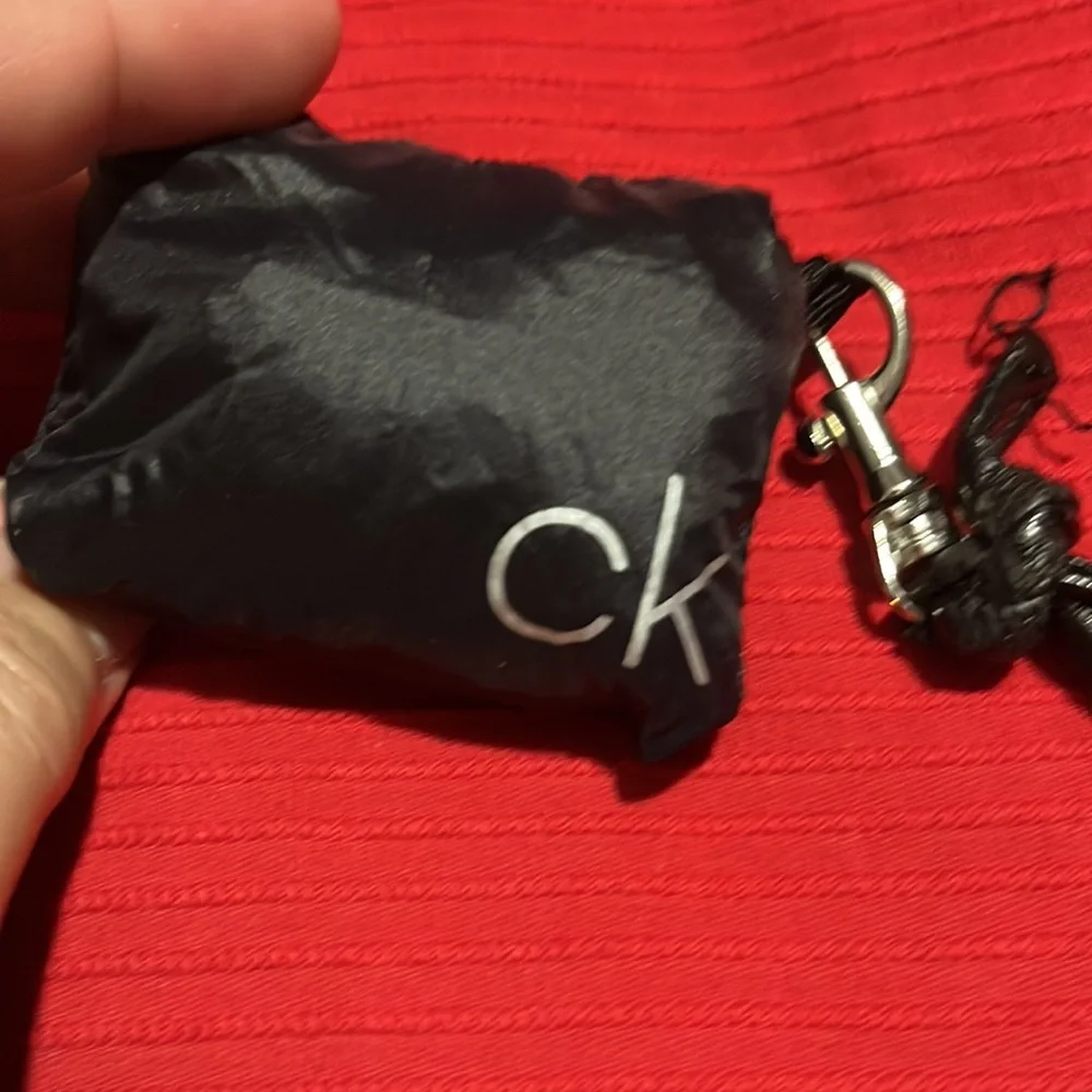 CK black draw string bag, used but great condition. Black and silver 12” x 5”